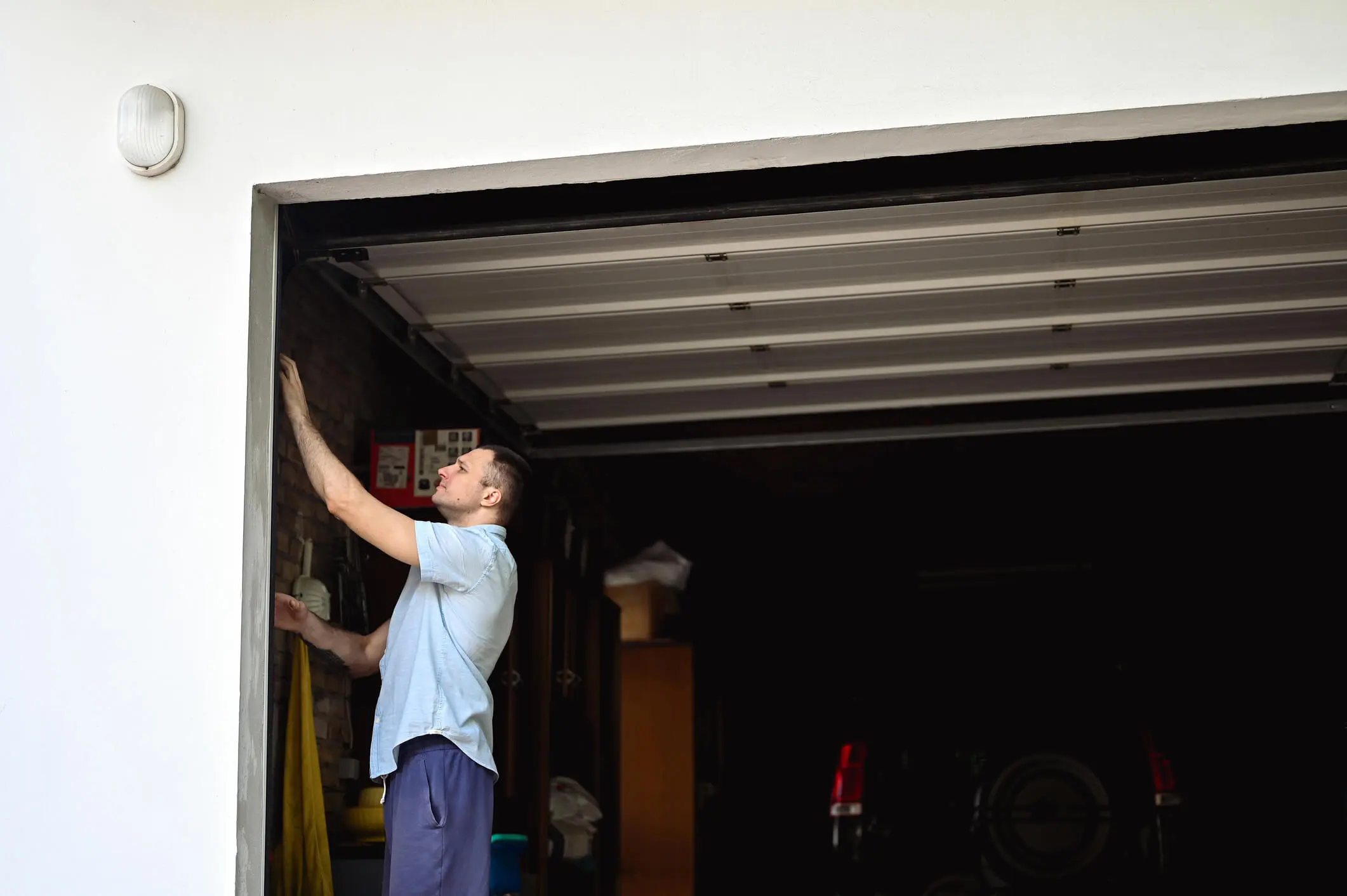 Man inspecting a garage door mechanism.