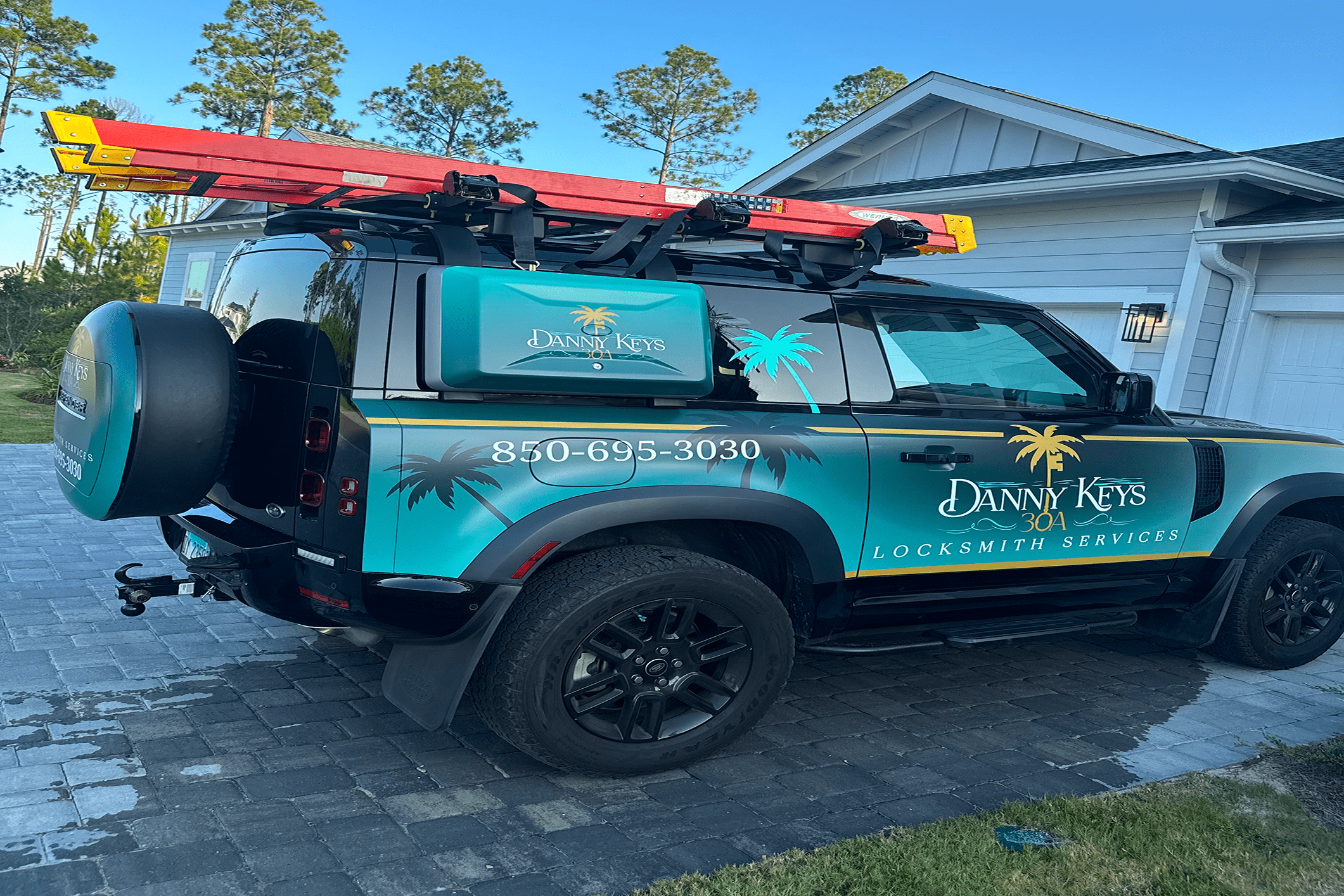 Locksmith service vehicle with ladders parked.