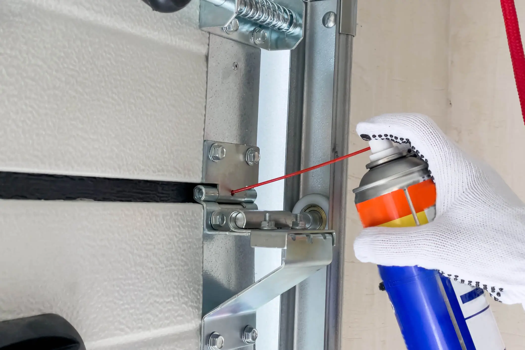 Lubricating a garage door hinge mechanism.