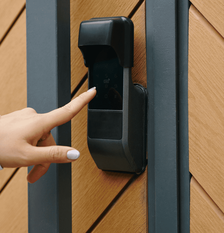 Finger pressing smart lock on wooden door.