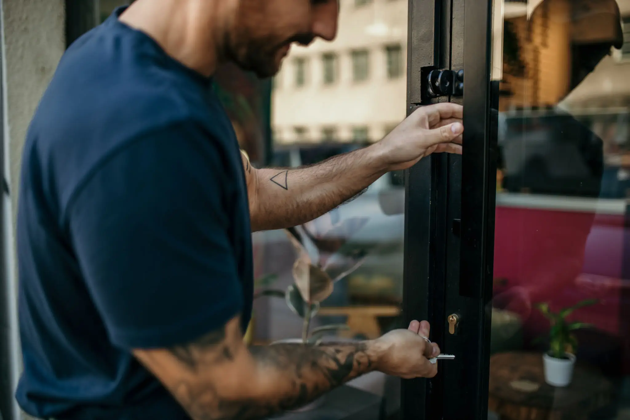 Man using a smartphone to scan a QR code on a glass door.