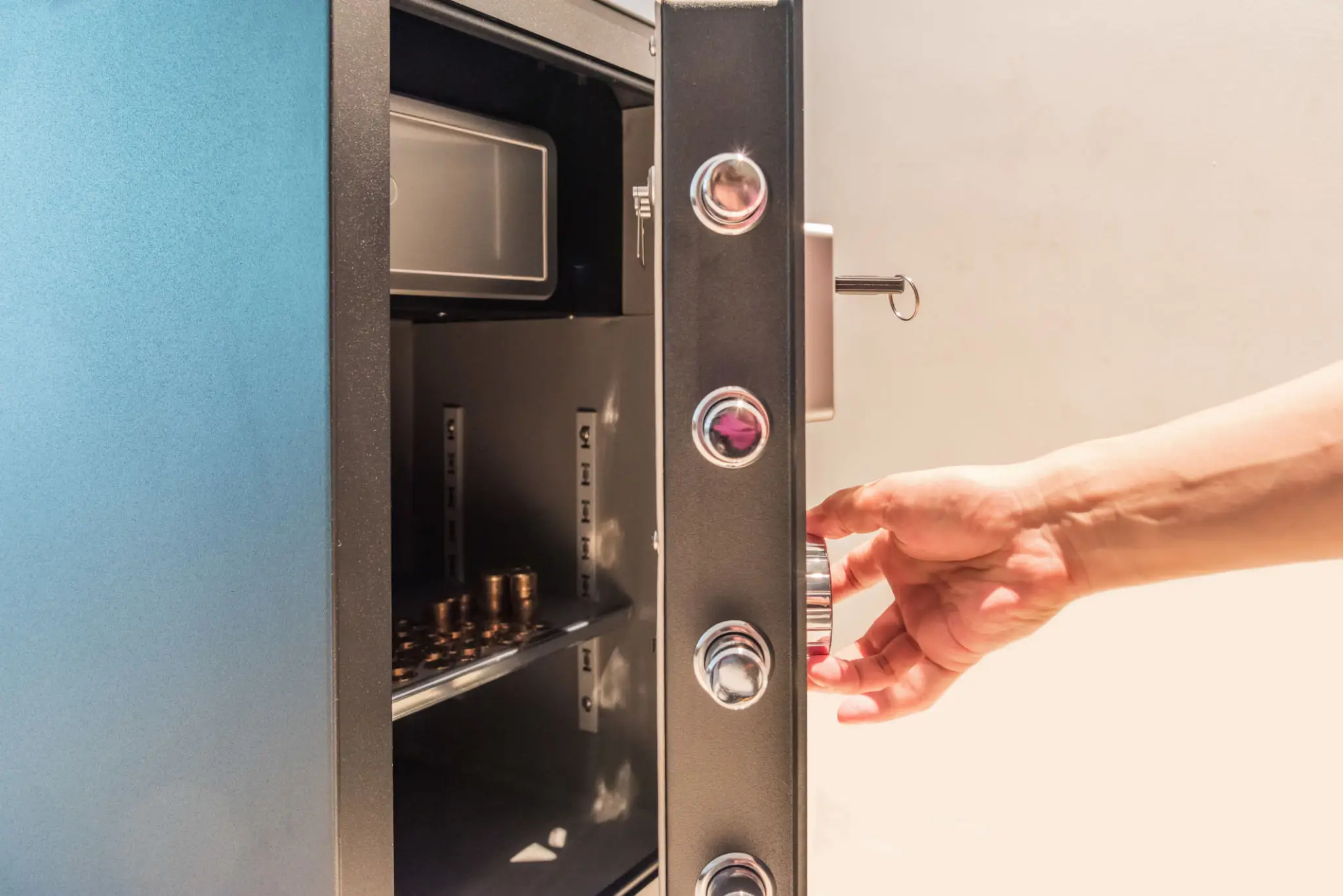 A hand opening a modern safe with multiple locking bolts.